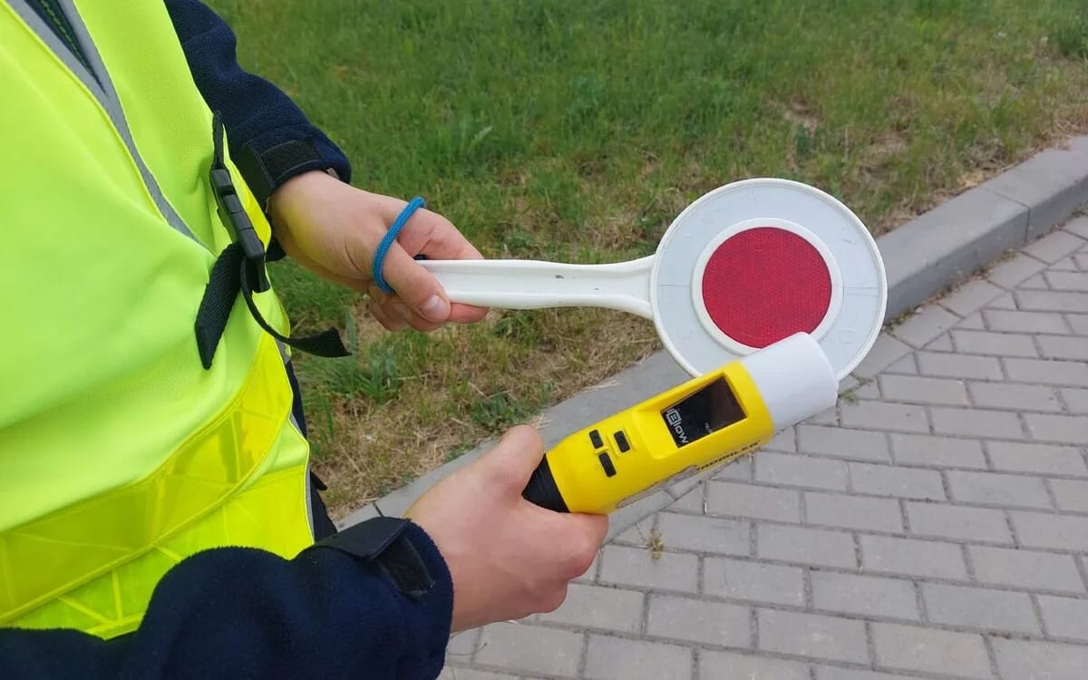 Policjant z alkomatem i lizakiem do zatrzymywania kierowców
