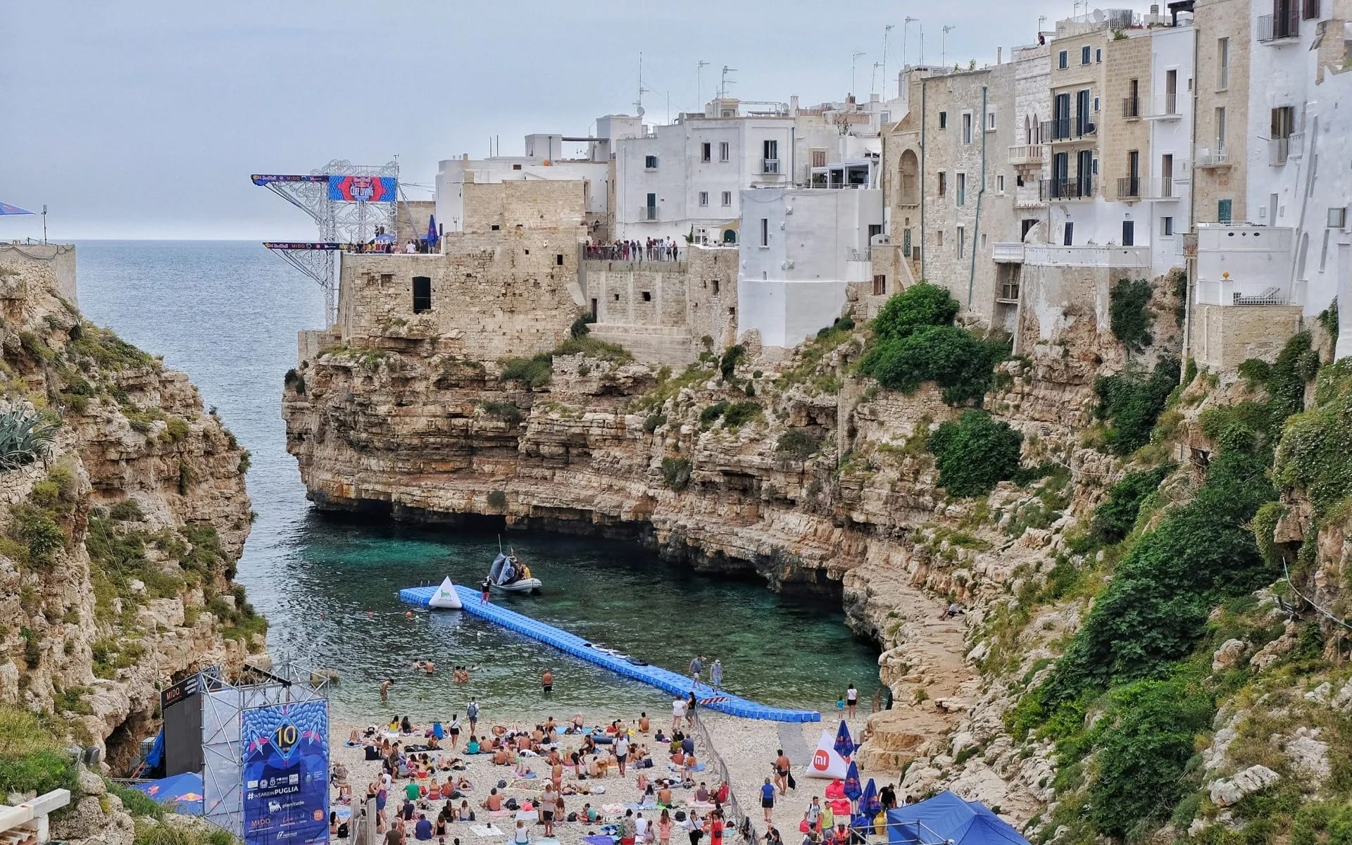 Widok z mostu na plażę, zatokę, klify we włoskim Polignano a Mare