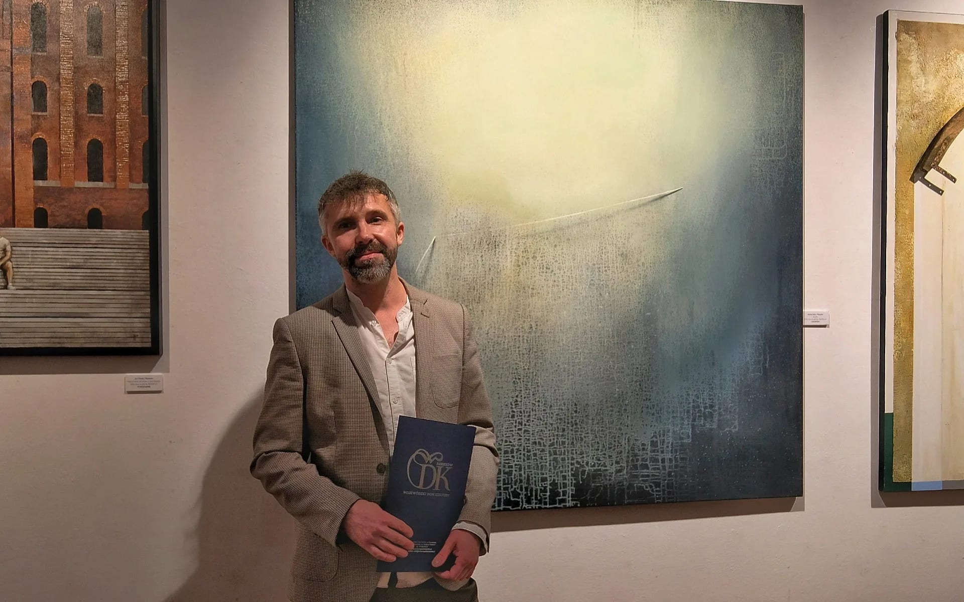 Marek Haba, artysta z Rzeszowa, na tle swojego obrazu "Światło"