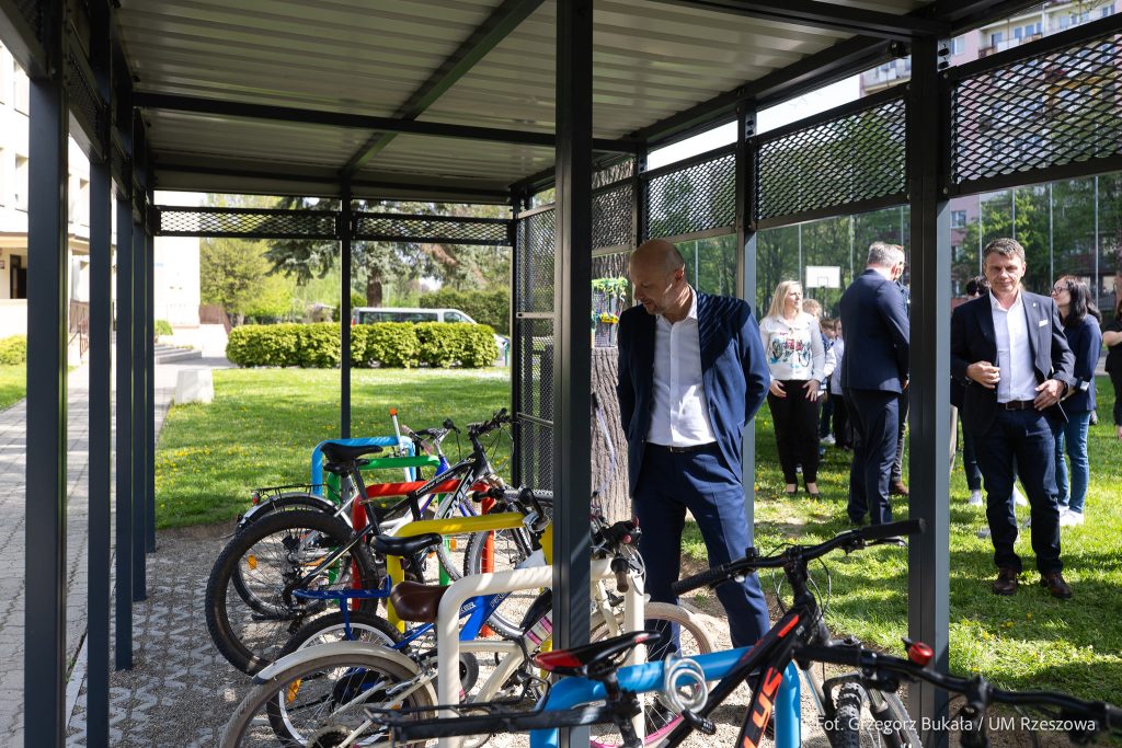 Prezydent Konrad Fijołek podziwia wiatę rowerową.