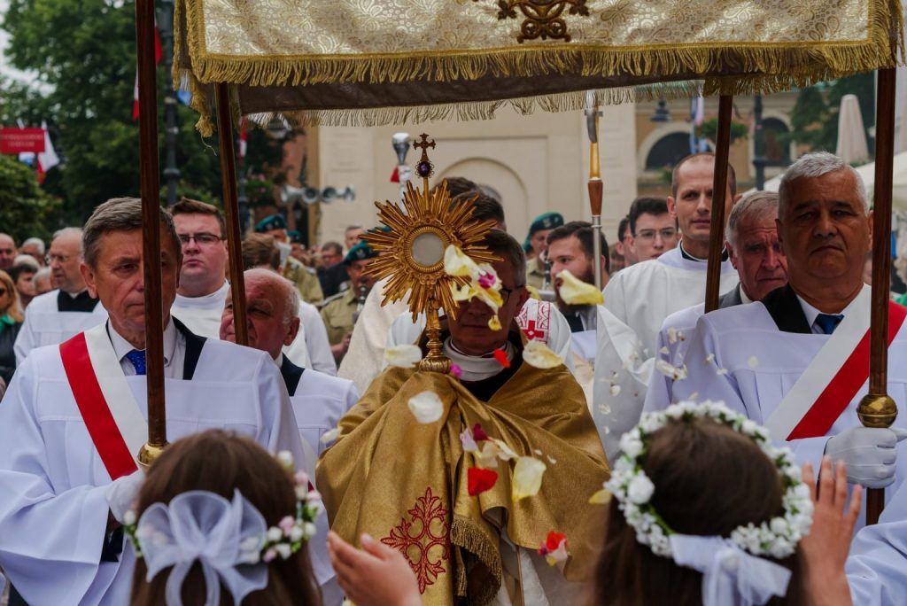 ksiądz i wierni idą w procesji Bożego Ciała