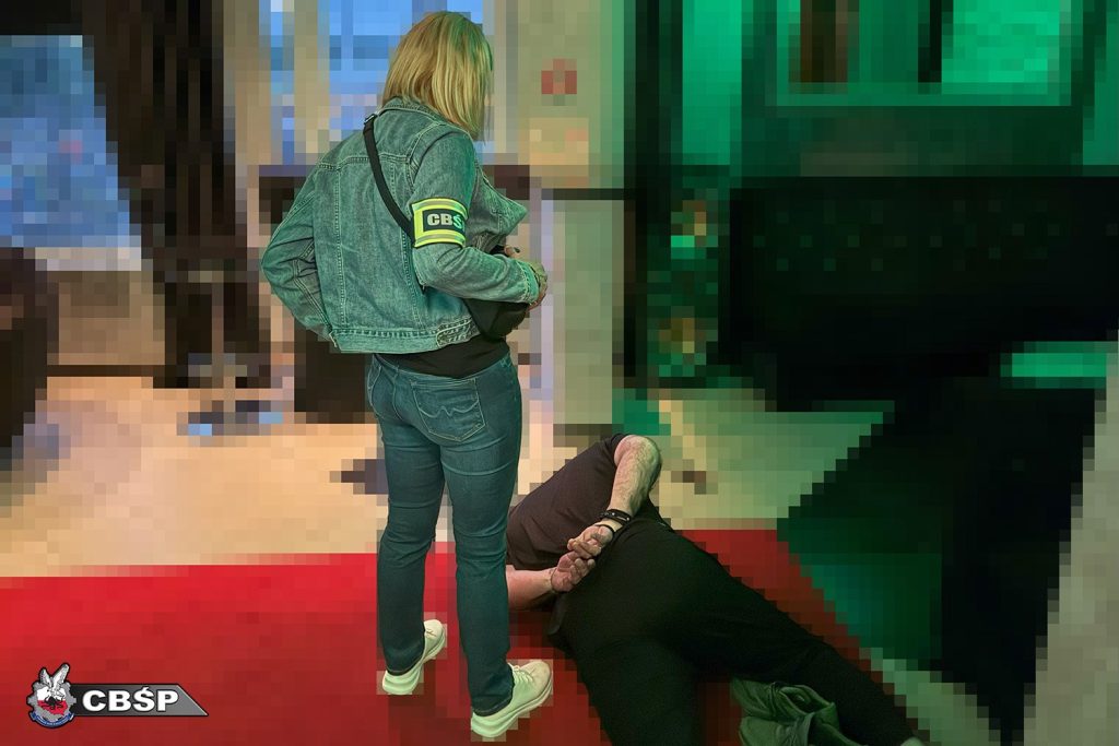 policjantka zatrzymuje podejrzanego w domu publicznym