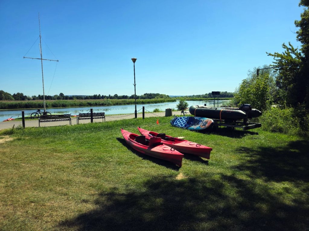 kajaki leżą na trawie nad rzeką