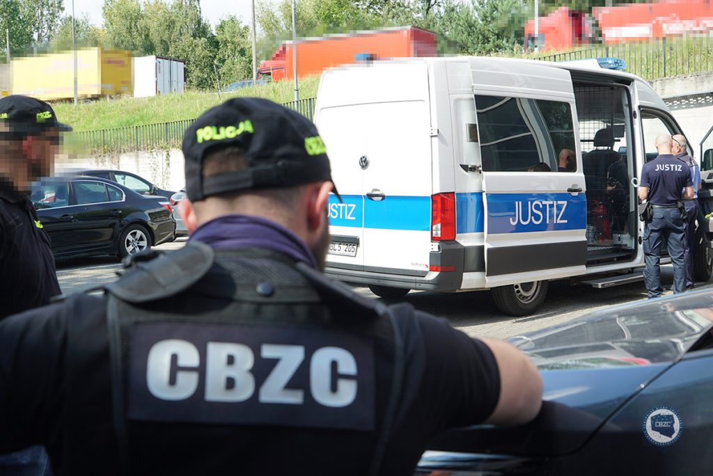 policjanci oraz radiowóz policyjny