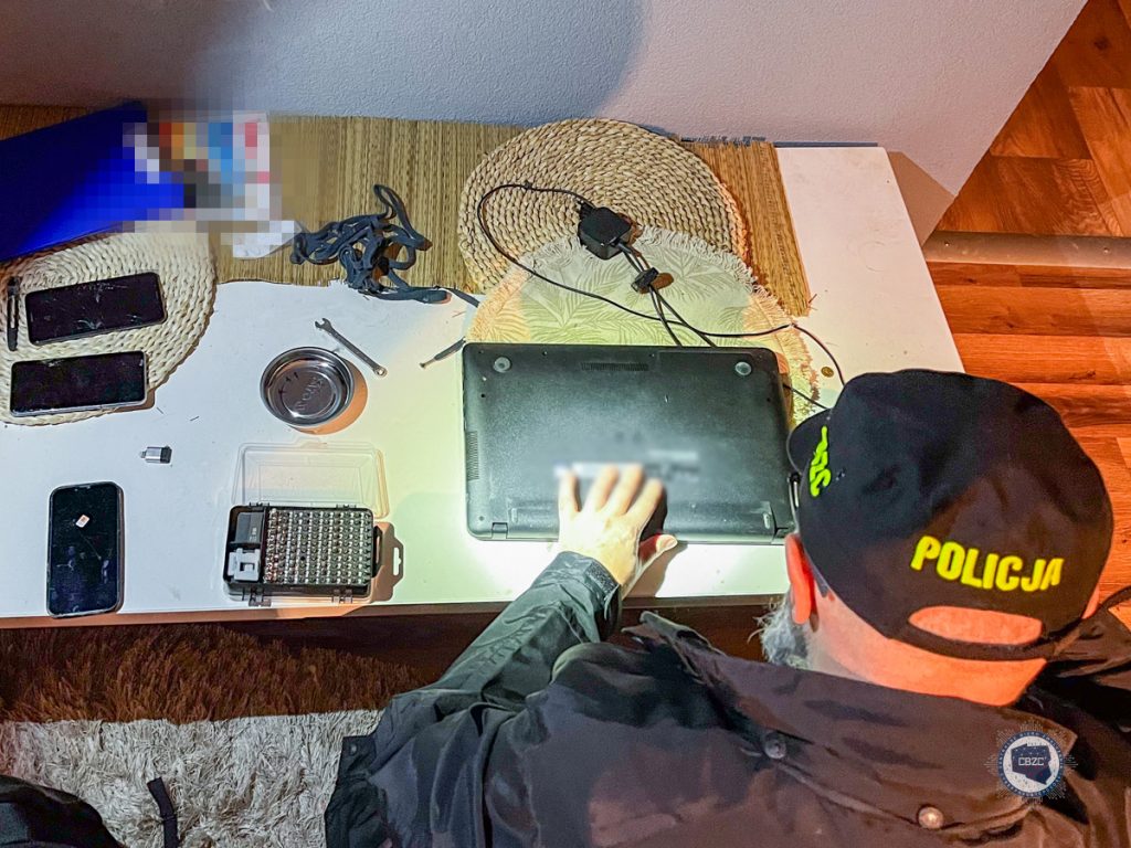 policjant robi przeszukanie w mieszkaniu