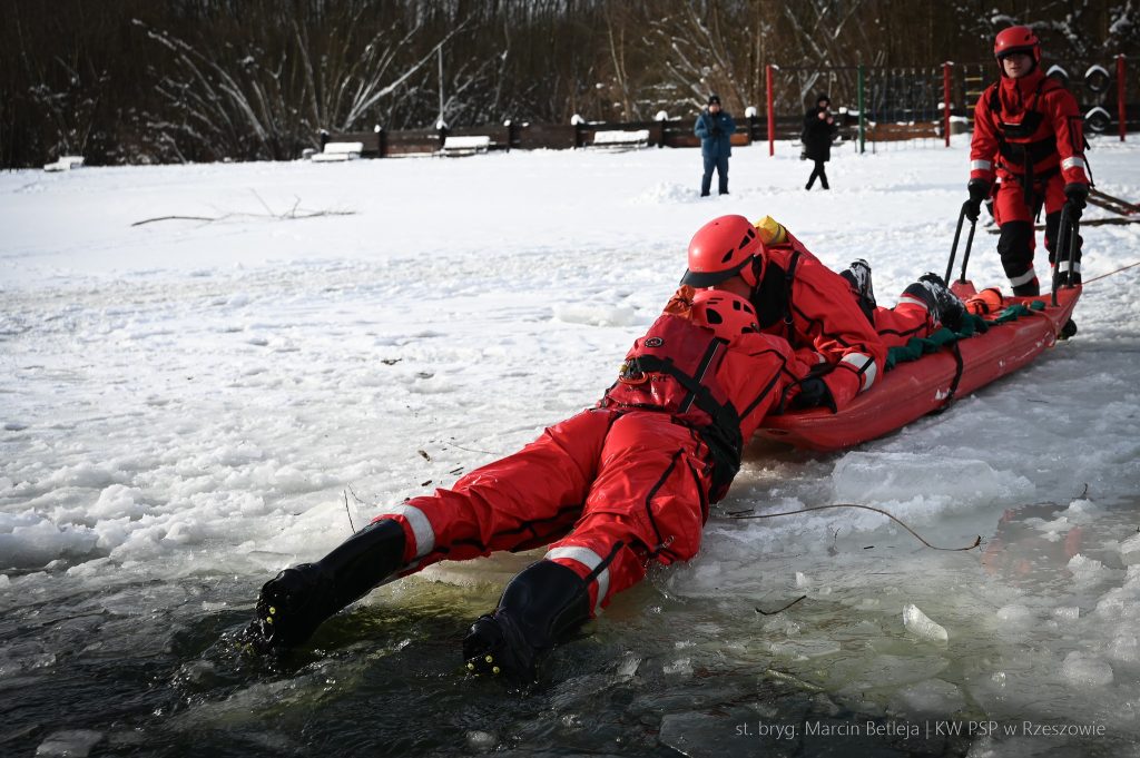 Strażacy wyciagają człowieka z zamarzniętego jeziora