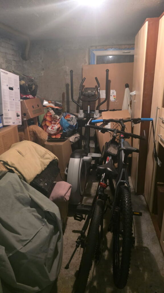 Piwnica pełna rowerów, ubrań i kartonowych pudeł