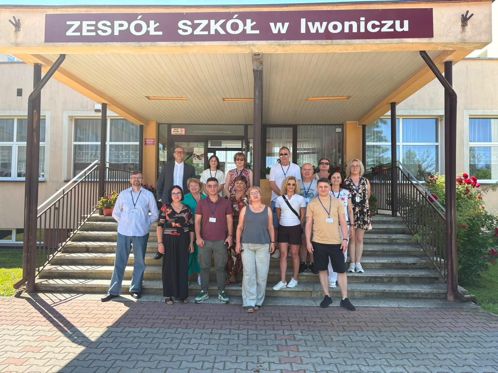 Pracownicy młodzieżowi stoją przed Zespołem Szkół w Iwoniczu