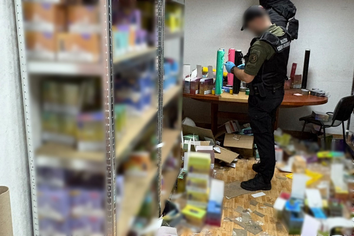 policjant przeszukujący magazyn z nielegalnymi papierosami